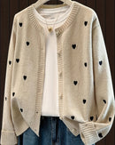 A rounded neckline and neatly covered buttons balance playful patterning, while ribbed trims lend definition to the textured knit.