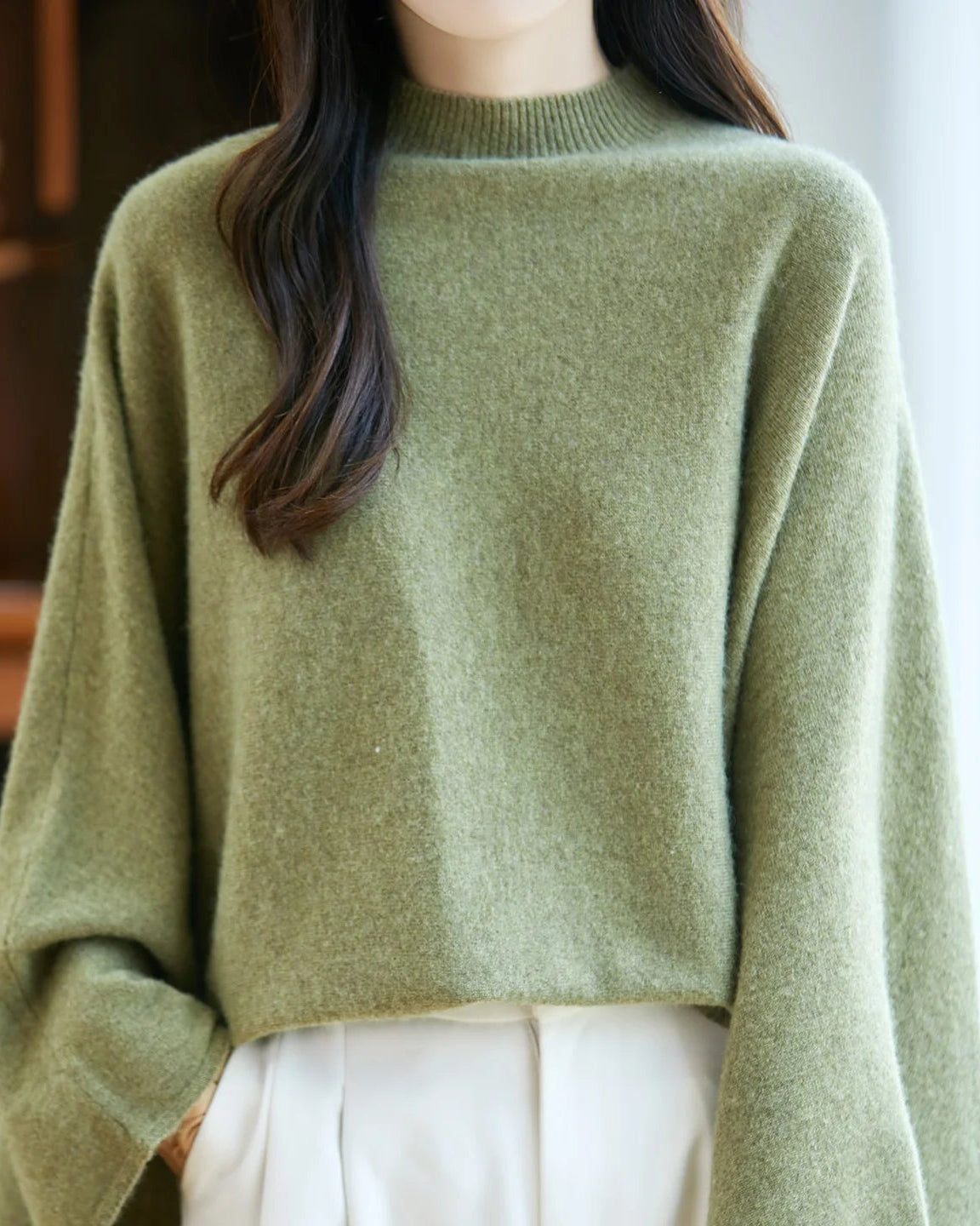 Wide sleeves create an expressive silhouette, while the ribbed mock neckline keeps the look considered and clean.