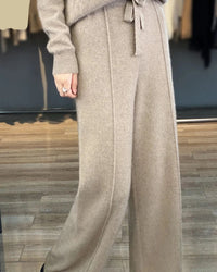 A pair of merino wool wide leg knit pants with a high elastic drawstring waist, designed for soft office-ready warmth that pairs easily with boots.
