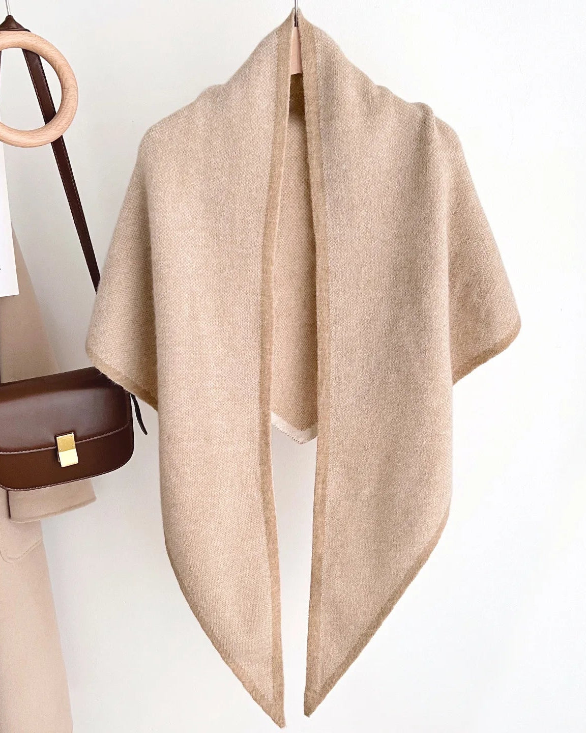 A wool blend composition and gently falling folds create a tactile layer that feels relaxed rather than formal.