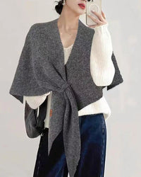 An oversized triangle wrap shawl crafted from a soft wool blend, featuring a lightweight knit and a generous 190x128cm drape for versatile, elegant warmth.