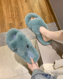 A pair of cross-strap plush house slippers featuring a soft cotton upper, a cozy fleece lining, and a durable rubber outsole for non-slip indoor comfort.
