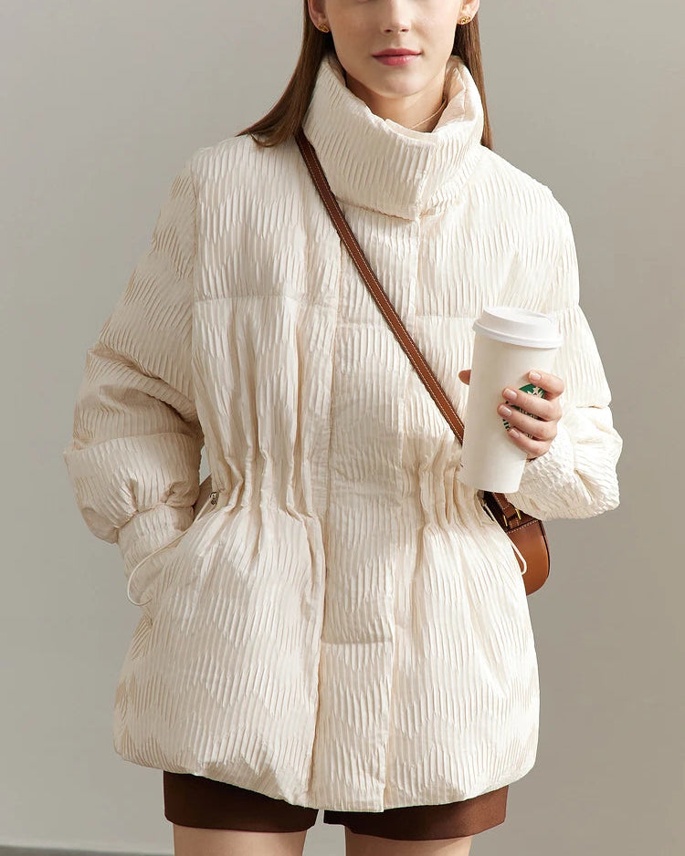 A crisp twill surface, stand collar, button accents, zip fastening, and functional pockets balance utility with understated style.