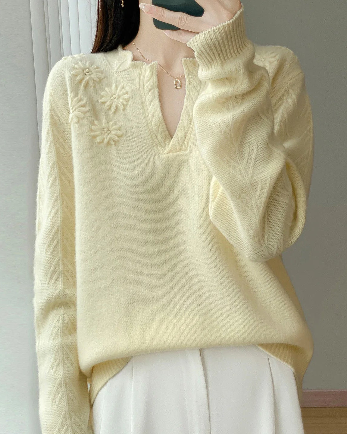 A floral-embroidered wool sweater with v-neck, floral embroidery, loose fit, long sleeves and stretch, designed for a cozy winter layering look that pairs from sneakers to boots.