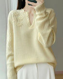 A floral-embroidered wool sweater with v-neck, floral embroidery, loose fit, long sleeves and stretch, designed for a cozy winter layering look that pairs from sneakers to boots.