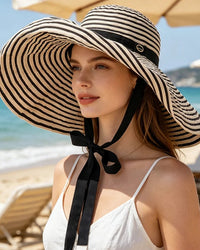 Oversized striped sun hat with windproof chin strap and foldable design. Full-face UV protection — lightweight polyester knit, ideal for beach and outdoor wear.