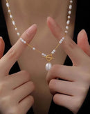 A long necklace featuring a gold-tone stainless steel chain with imitation pearl beads and a functional OT clasp, designed for an elegant, layered look.