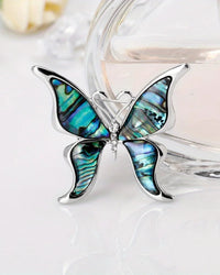 Gold butterfly brooch with shell accents, metal pin accessory with intricate wings, perfect for adding elegance to any outfit.