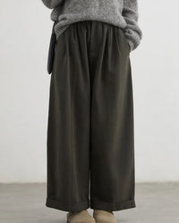 A pair of high-waist wide-leg casual trousers featuring front pleats, a zipper fly, and a relaxed fit for a comfortable, elongated silhouette.