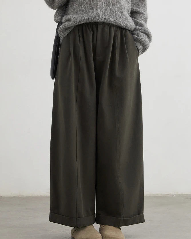 A pair of high-waist wide-leg casual trousers featuring front pleats, a zipper fly, and a relaxed fit for a comfortable, elongated silhouette.