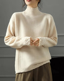 A softly raised neckline offers gentle coverage, while the raglan sleeves create a natural shoulder line and relaxed movement.