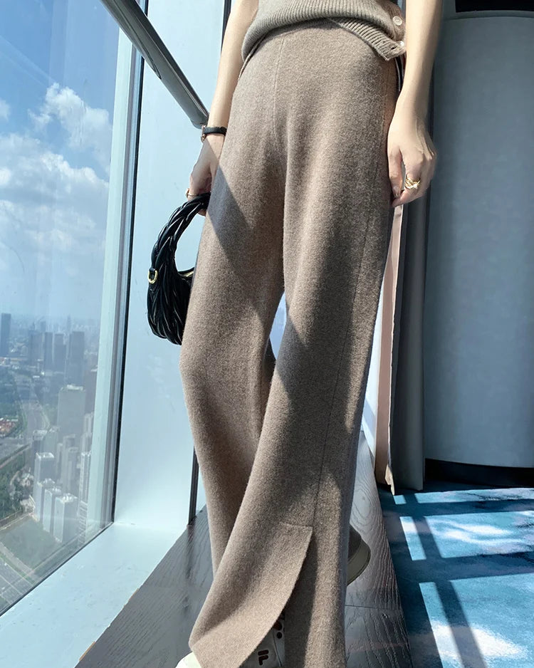 A pair of merino wool slit wide-leg trousers featuring a seamless knit, an elastic waist, and a graceful side slit for an elongated, fluid silhouette.