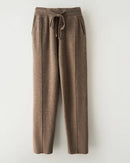 A merino wool tapered knit pants with high elastic waist, tapered legs, ankle length and slight stretch, designed for a cozy winter layering look that pairs from sneakers to boots.