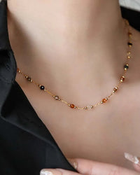 A clavicle necklace featuring natural stone beads on a stainless steel chain with a lobster clasp, designed for a bohemian, free-spirited look.
