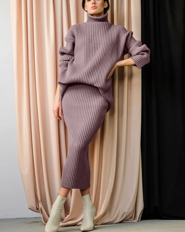 Elegant two-piece knit set featuring a dusty rose turtleneck sweater and a matching midi skirt. This ribbed acrylic suit offers a comfortable and chic look for the fall and winter seasons.
