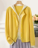 A heavyweight double-breasted cashmere hooded cardigan with double-breasted button front, hooded neckline and loose fit, designed for a cozy winter layering look that pairs from sneakers to boots.