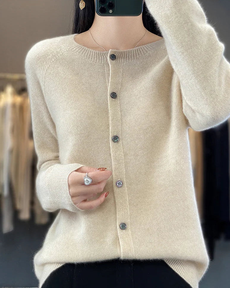 A pure wool O-neck cardigan with a button-front closure and ribbed trim, designed for a soft, classic look suitable for layering.