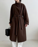 An oversized mid-length trench coat featuring a stand collar, belt-tie waist, and a relaxed fit for a minimalist, all-season look.