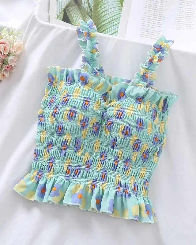 A sleeveless polyester vest featuring a bold floral print and fold detail at the neckline, with a short bohemian silhouette for a breezy summer look.