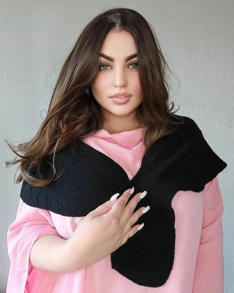 A 100% wool fishtail shawl with an openwork knit and small cape silhouette, designed for lightweight warmth that layers neatly over coats and knits.