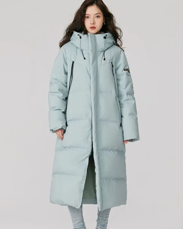 Longline hooded duck down coat with white duck down fill, horizontal quilting, integrated hood, front zip and long zip pockets, a warm below-knee fall-winter coat for commutes.