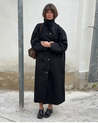 The generous, relaxed fit allows for natural, easy movement, while the stand collar and full-length drop create an imposing yet approachable silhouette.