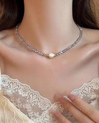 A delicate necklace featuring a single freshwater pearl centered on a beaded crystal chain with a 14K gold-filled clasp, designed for an elegant look.