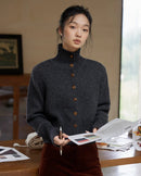 A thick cashmere cardigan with a half high stand collar and single-breasted buttons, designed for a loose cropped fit that layers neatly under coats.
