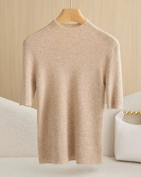 A wool mock neck half sleeve top with a slim fit, designed for lightweight layering that pairs easily with trousers and skirts for office or weekend wear.