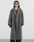A loose long wool blend coat with a V-neck and double-breasted front, designed for polished warmth that layers easily from commute to evening plans.