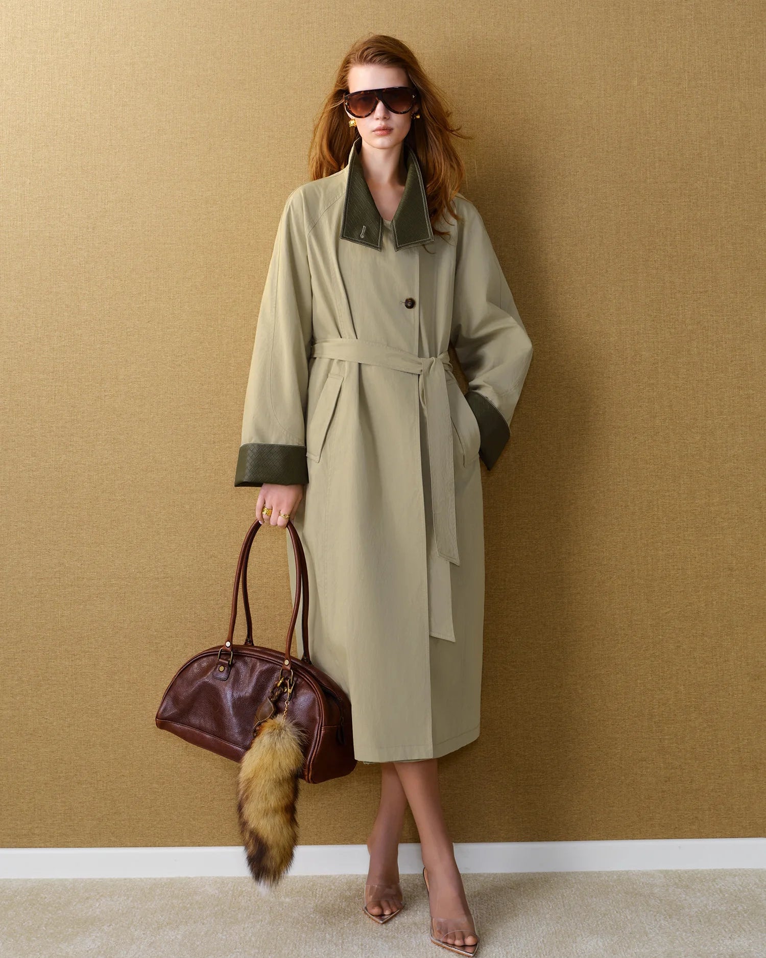 The woven cotton-blend fabric drapes beautifully, while the single-breasted closure and belted waist lend a timeless, editorial quality.