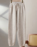 A pair of merino wool drawstring pencil trousers featuring a seamless knit, side pockets, and an elastic waist for a sleek, comfortable fit.