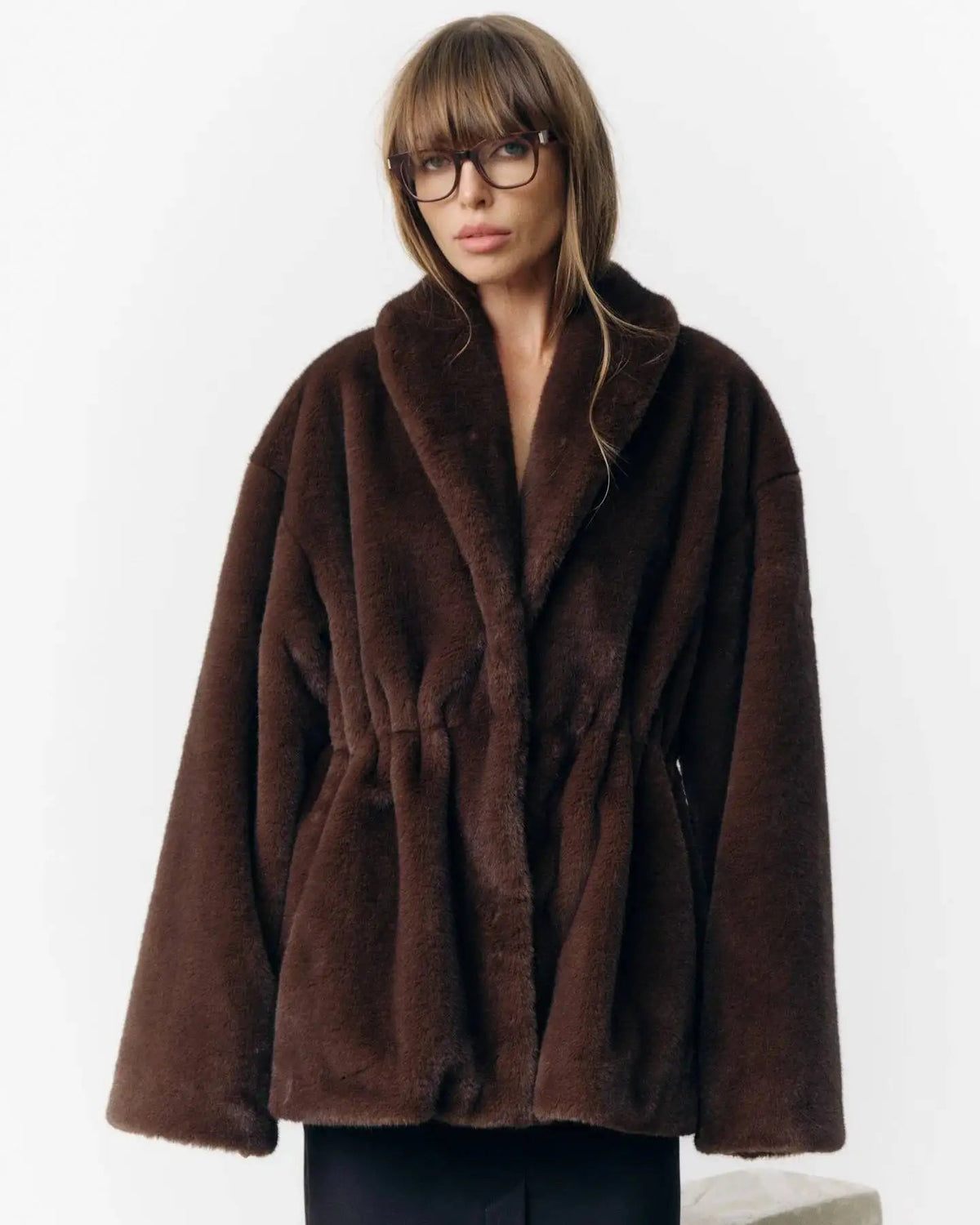 A thickened faux fur winter coat with a turn-down collar and single-breasted front, designed for a plush, warm look in cold weather.