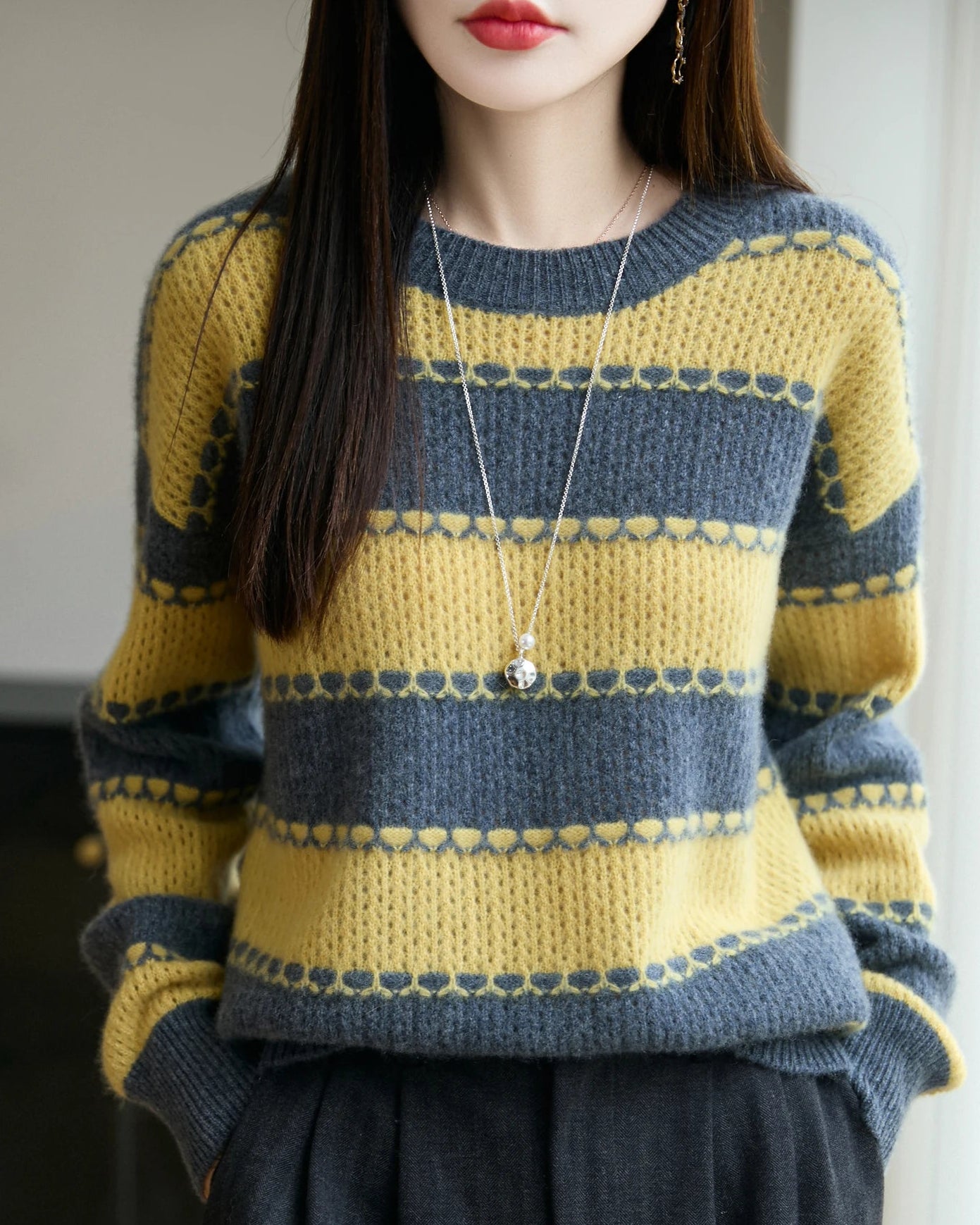 A long-sleeve pullover crafted from merino wool, featuring a round neck, block stripe pattern, and a relaxed fit for a cozy, sophisticated look.