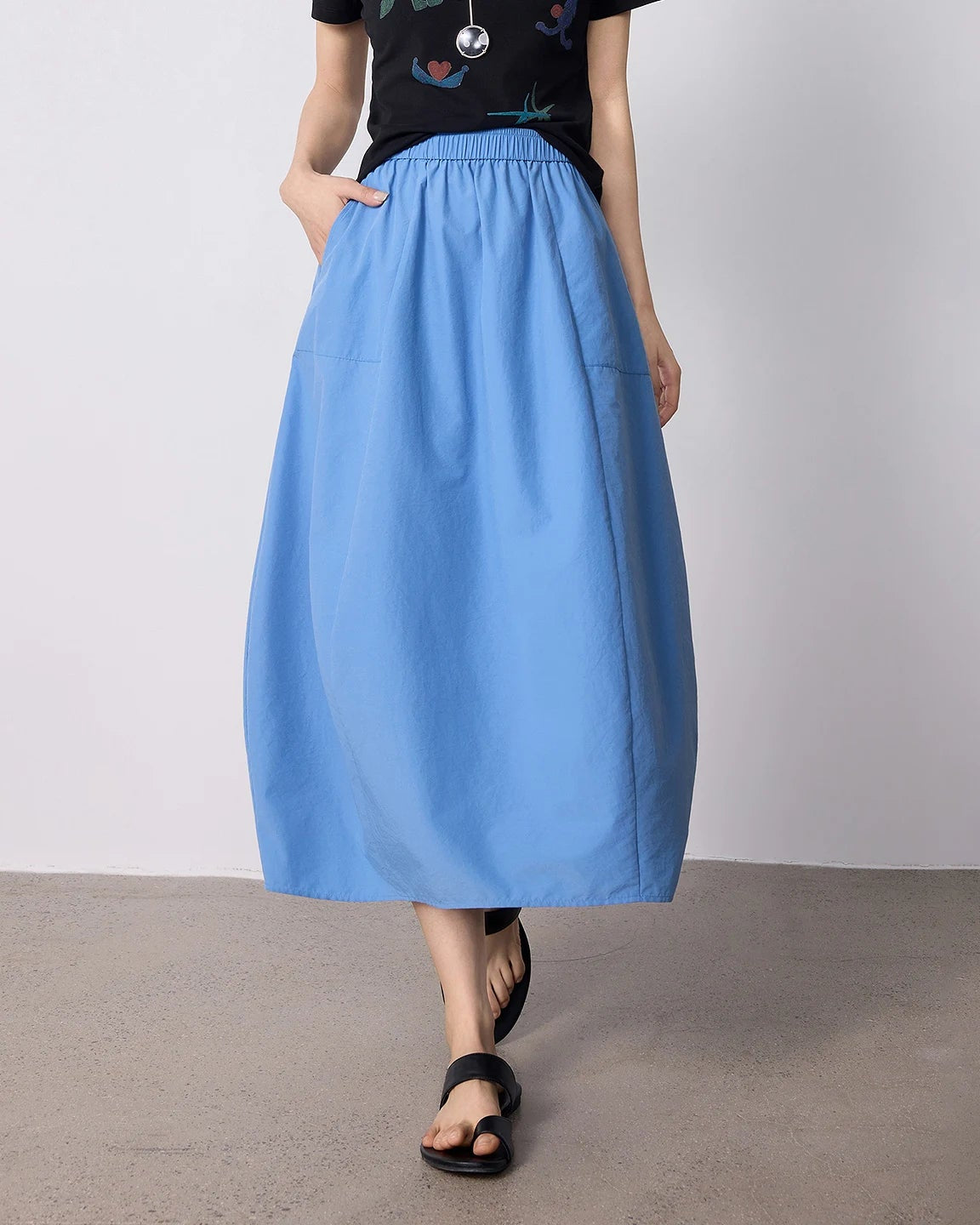 High-waist cocoon-shape midi skirt with a slimming A-line silhouette and textured wrinkle finish. Solid colour, slim fit — effortless casual style for summer.