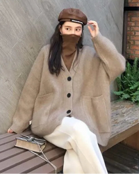 A mid-length cashmere cardigan with a deep V-neck and button front, designed for a loose fit that layers easily over knits and dresses.