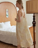 Woman drifting off in a satin-bamboo shadow-print nightgown, silky drape and bamboo fibers keep you cool and dry—your eco-luxurious choice for 70-85 °F summer nights.