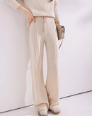 Cable-knit wool wide-leg pants for women with vertical cable panels, drawstring waist and full-length wide-leg shape, a warm fall-winter knit trouser for relaxed everyday wear.