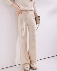 Cable-knit wool wide-leg pants for women with vertical cable panels, drawstring waist and full-length wide-leg shape, a warm fall-winter knit trouser for relaxed everyday wear.