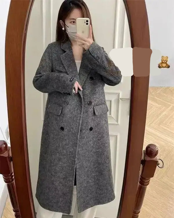 A longline coat crafted from a thick wool and cashmere blend with a turn-down collar and lace-up waist, designed for quiet winter warmth.