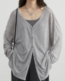 A lightweight polyester-viscose V-neck cardigan with a button front and loose fit, designed for soft polished ease that layers from workdays to weekends.