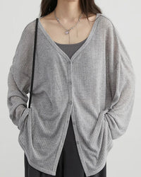 A lightweight polyester-viscose V-neck cardigan with a button front and loose fit, designed for soft polished ease that layers from workdays to weekends.