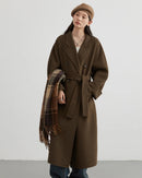 A long wool-blend coat with a double-faced finish and turn-down collar, designed for a loose, warm silhouette that drapes easily over layers.