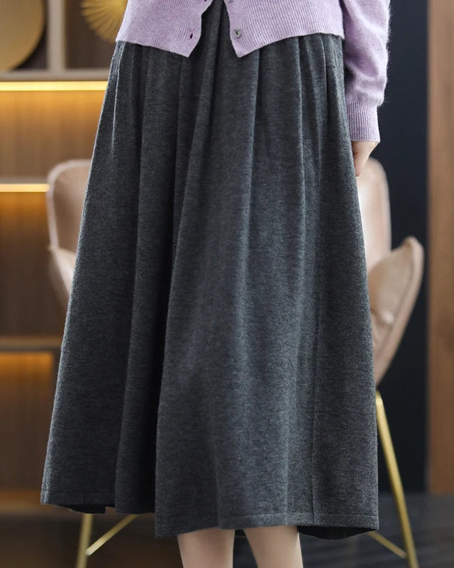 A loose, mid calf silhouette flows from a softly defined waist, while the fine knit offers breathable warmth and a gentle hand feel.