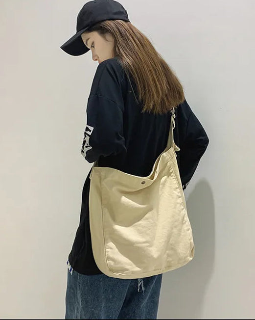 The single strap offers flexible crossbody or shoulder carrying, while the hasp closure adds a considered finishing touch.