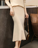 A merino wool knit midi skirt with a trumpet hem and natural waist, designed for a soft, warm look that moves easily from day to night.