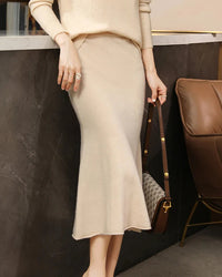 A merino wool knit midi skirt with a trumpet hem and natural waist, designed for a soft, warm look that moves easily from day to night.
