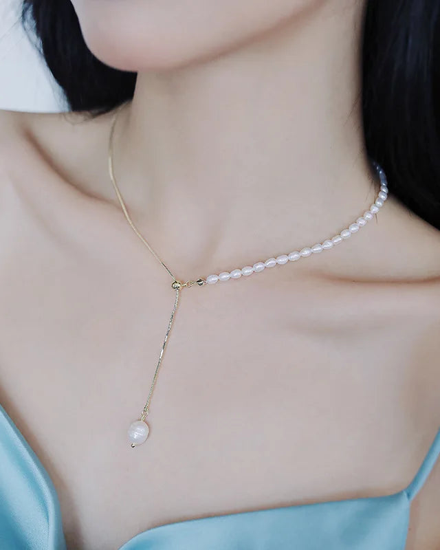 A delicate necklace featuring a lustrous freshwater pearl drop pendant on a fine chain, designed for an elegant, minimalist look with a secure lobster clasp.