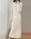 The knit texture offers a smooth, comforting touch, while a defined waistline and sweeping hem shape a serene profile.