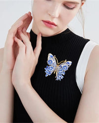 Colorful butterfly shaped brooch in gold tone, vibrant enamel wings with multicolor accents and intricate metal detailing, perfect for adding playful elegance.

